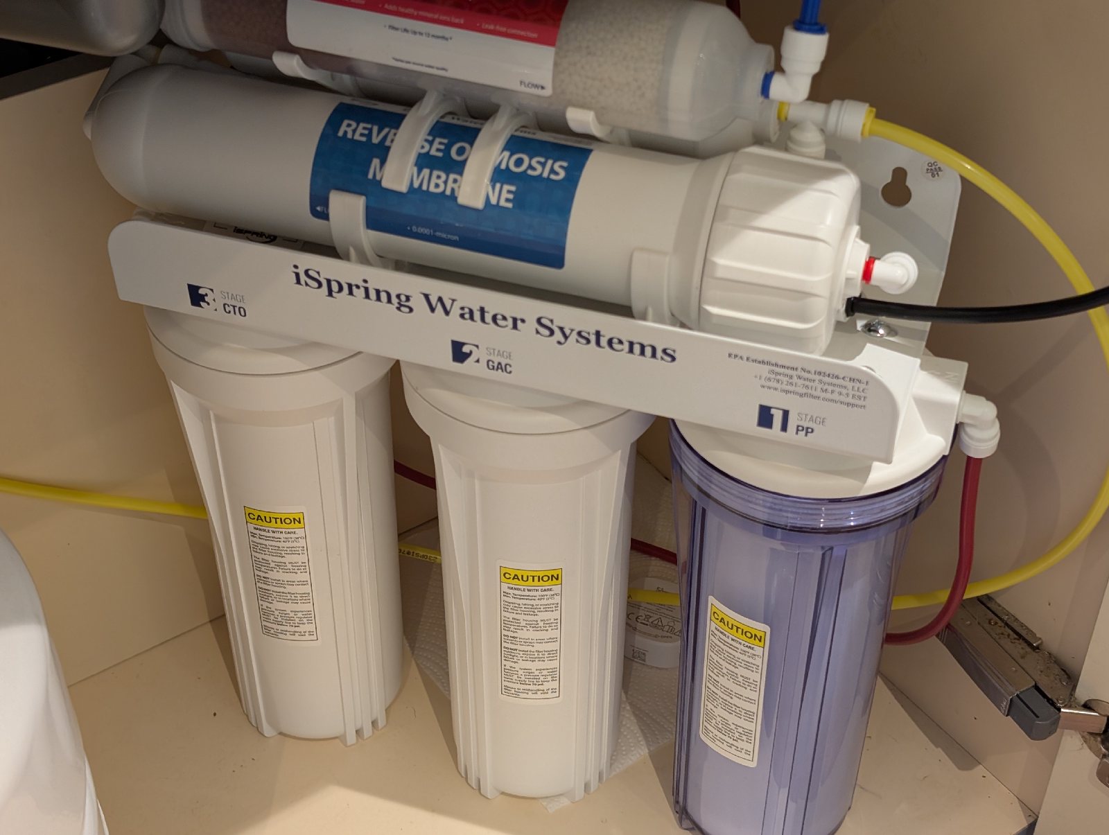 A leak sensor placed on kitchen tissue beside the reverse osmosis system under the sink